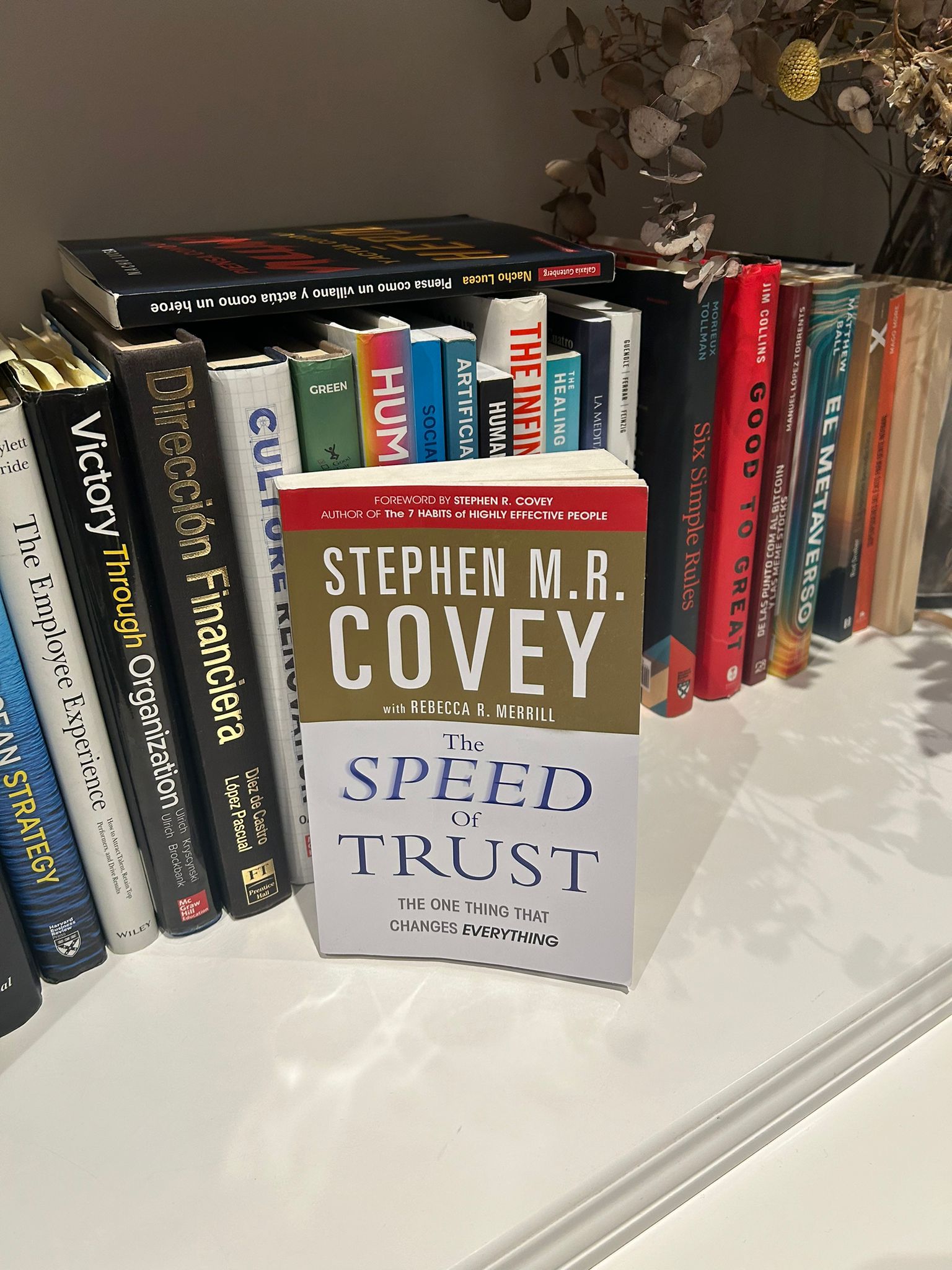 Libro The Speed of Trust de Stephen M. R. Covey en pie sobre una estantería con otros títulos