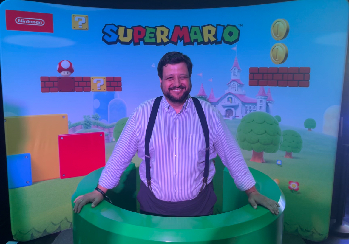 Manu Soriano posa sonriente en un photocall de Super Mario de Nintendo asomado a una tubería verde