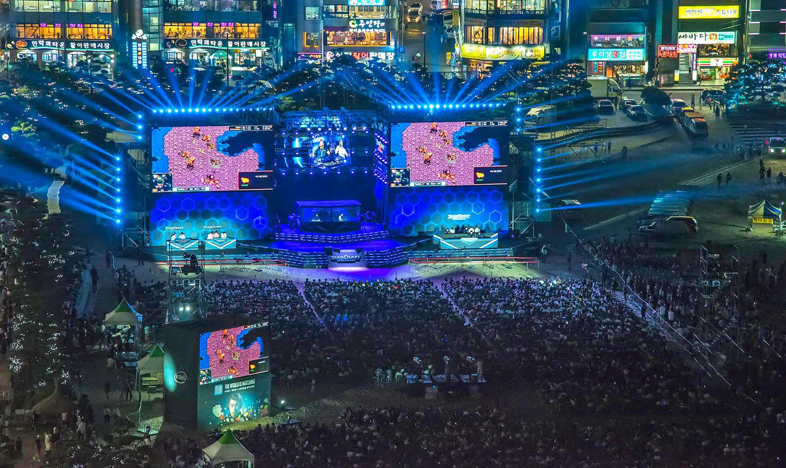 Escenario nocturno de la final de StarCraft II en Corea del Sur con pantallas gigantes y multitud