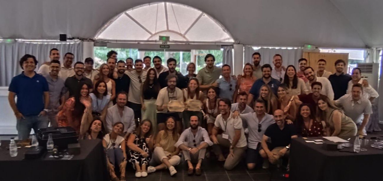 Foto de grupo de todo el equipo de W Executive posando en una carpa durante la fiesta de verano