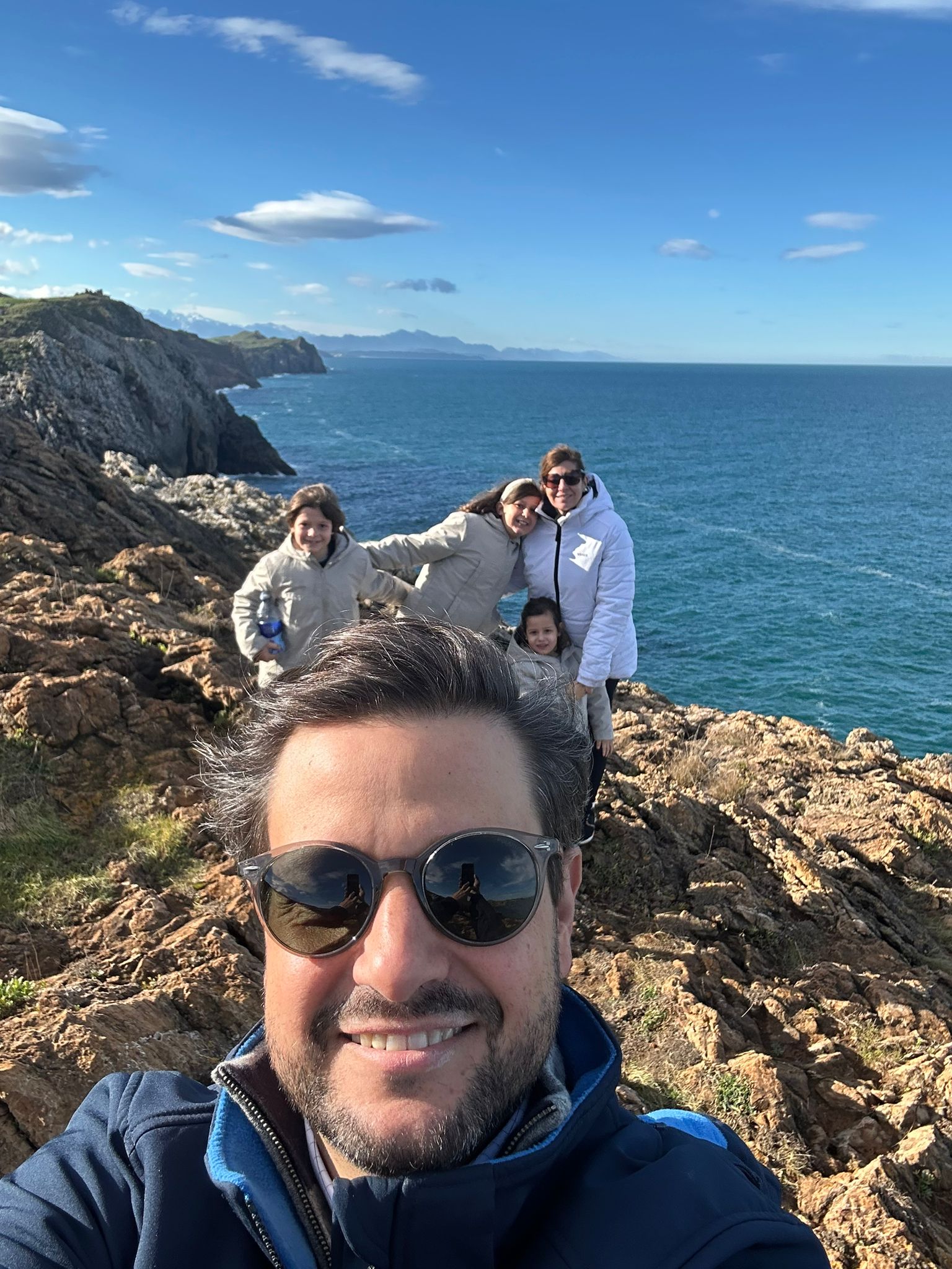 Selfie de Manu Soriano con su familia en un acantilado de Cantabria frente al mar en diciembre de 2025