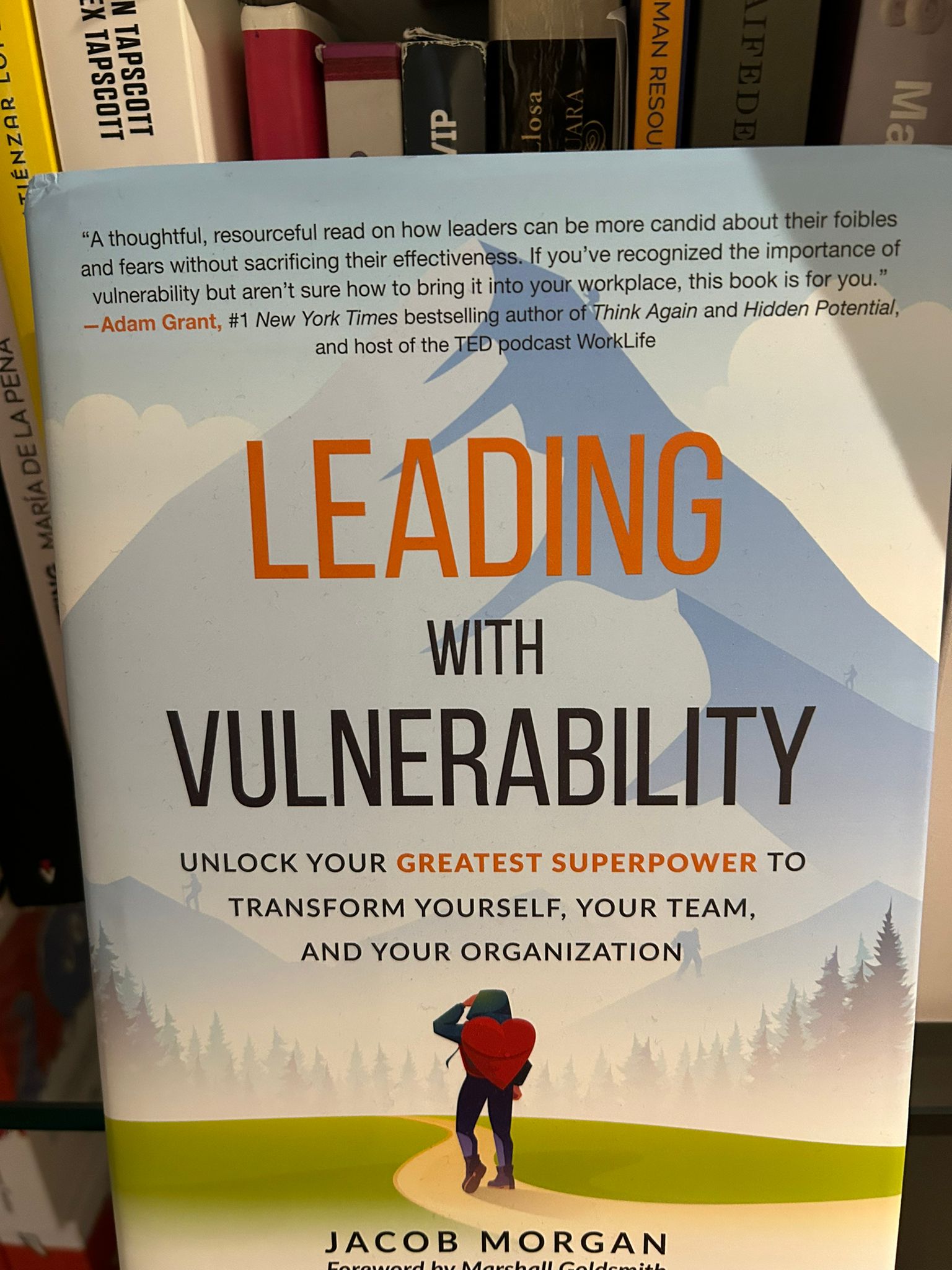 Libro Leading with Vulnerability de Jacob Morgan con un excursionista y una montaña