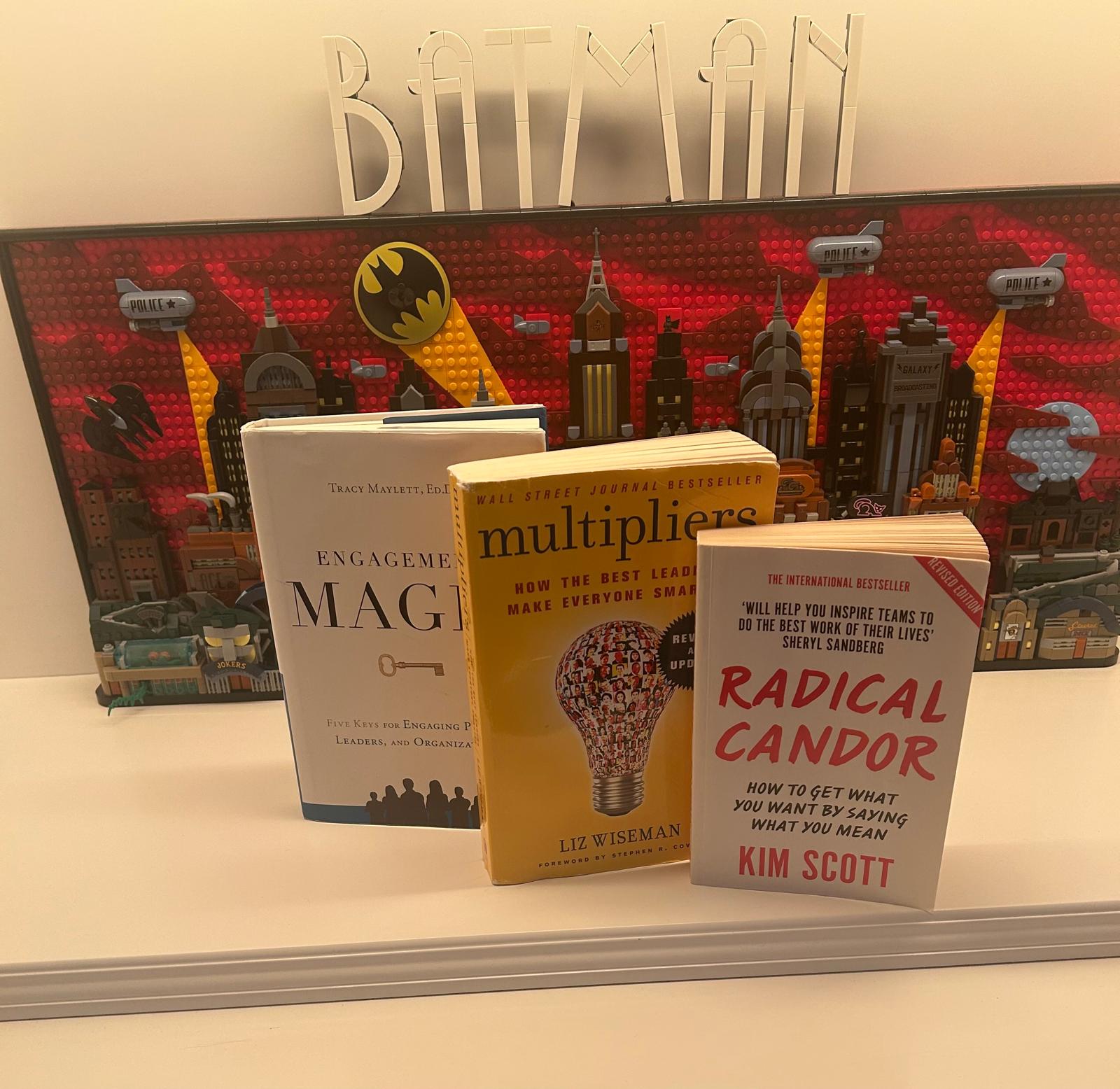 Libros Engagement Magic, Multipliers y Radical Candor ante un cuadro de Batman