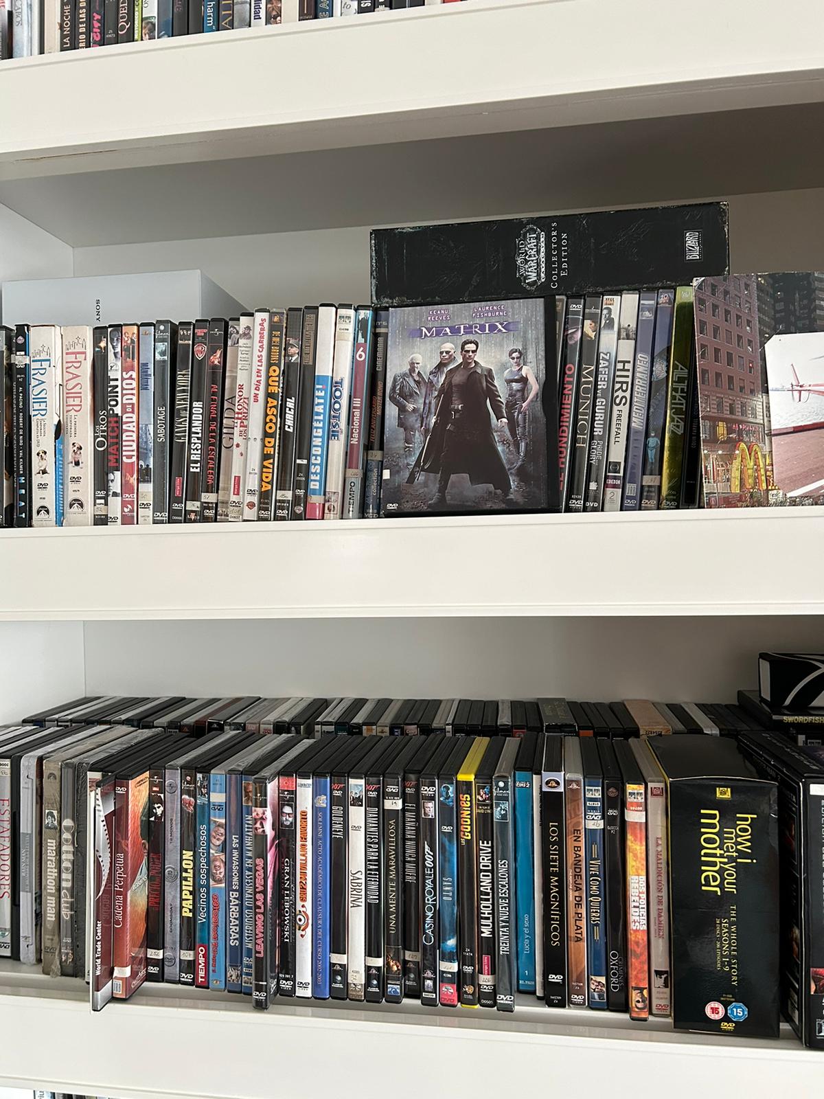 Estanteria con coleccion de DVDs donde destaca la pelicula Matrix en primer plano