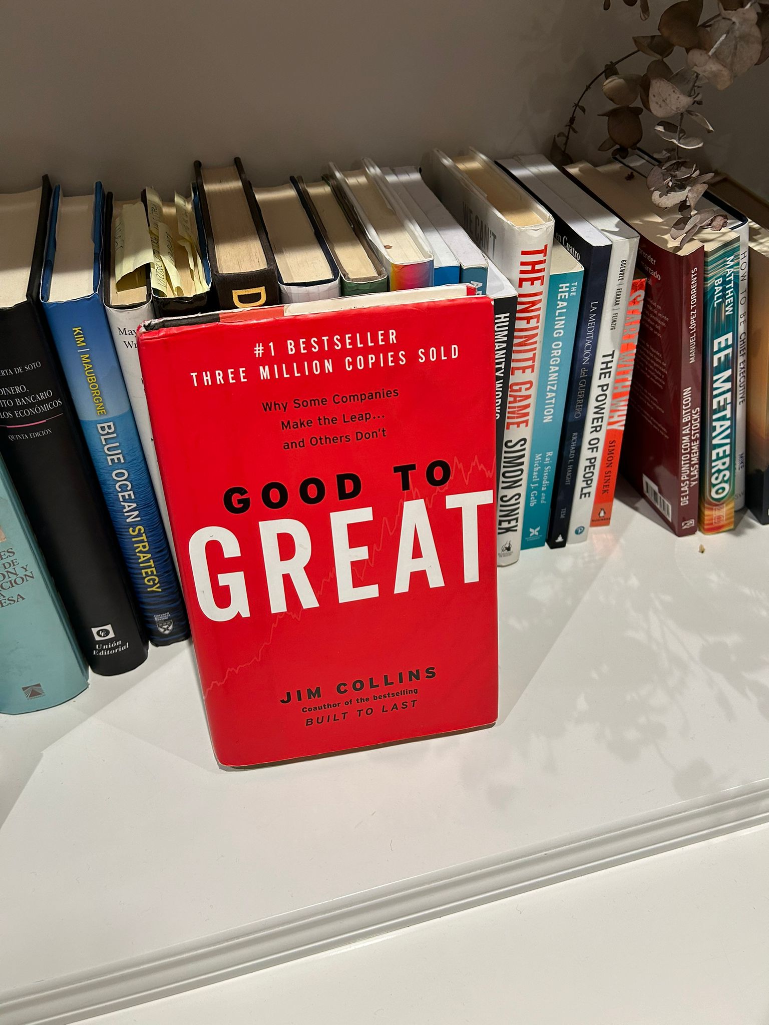 Libro Good to Great de Jim Collins, con portada roja, sobre una estanteria de libros