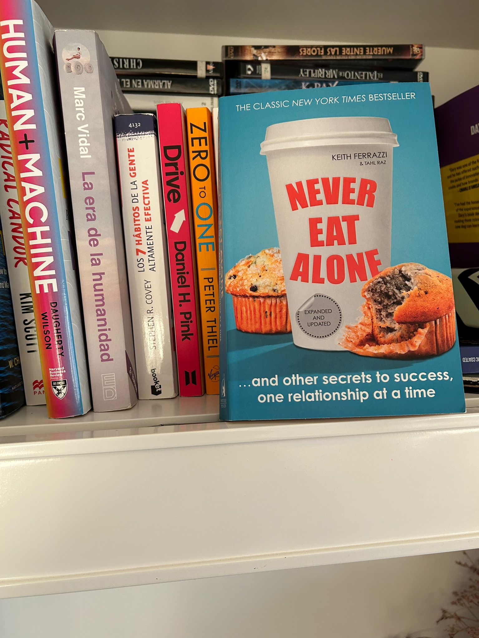 Libro Never Eat Alone de Keith Ferrazzi sobre una estanteria junto a otros titulos de negocios