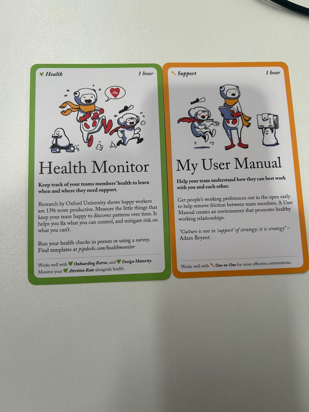 Cartas Health Monitor y My User Manual de la baraja Team Tactics con sus textos en inglés
