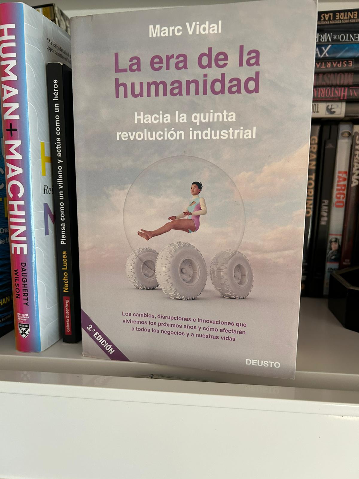 Libro La era de la humanidad de Marc Vidal junto al libro Human + Machine en una estantería
