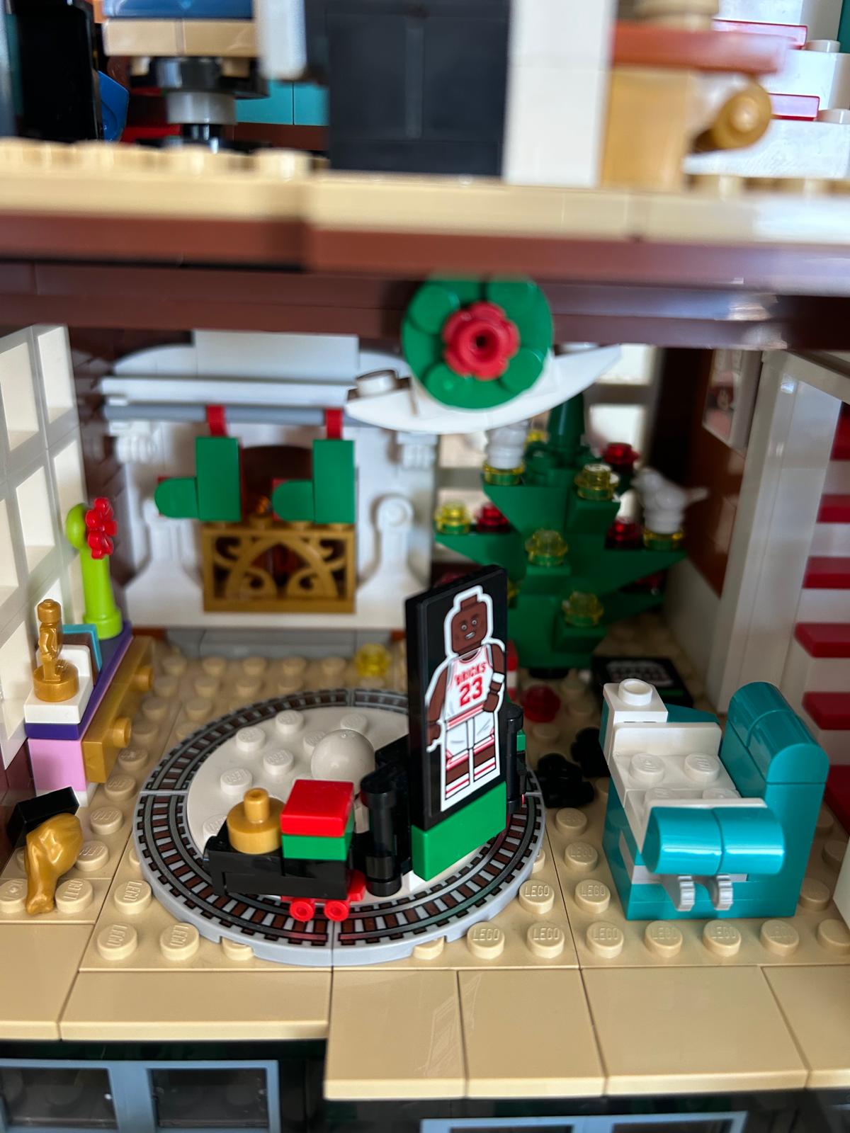 Detalle LEGO del salón con chimenea, árbol de Navidad y tren de juguete sobre vías
