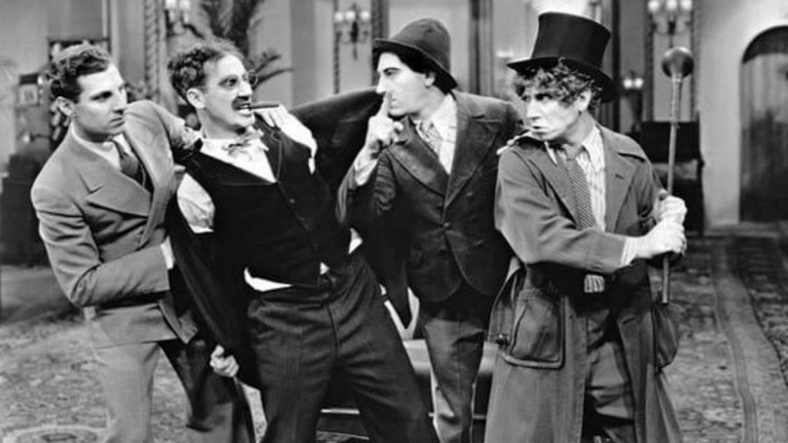 Los cuatro Hermanos Marx en un hotel, con Harpo de chistera, en una escena en blanco y negro