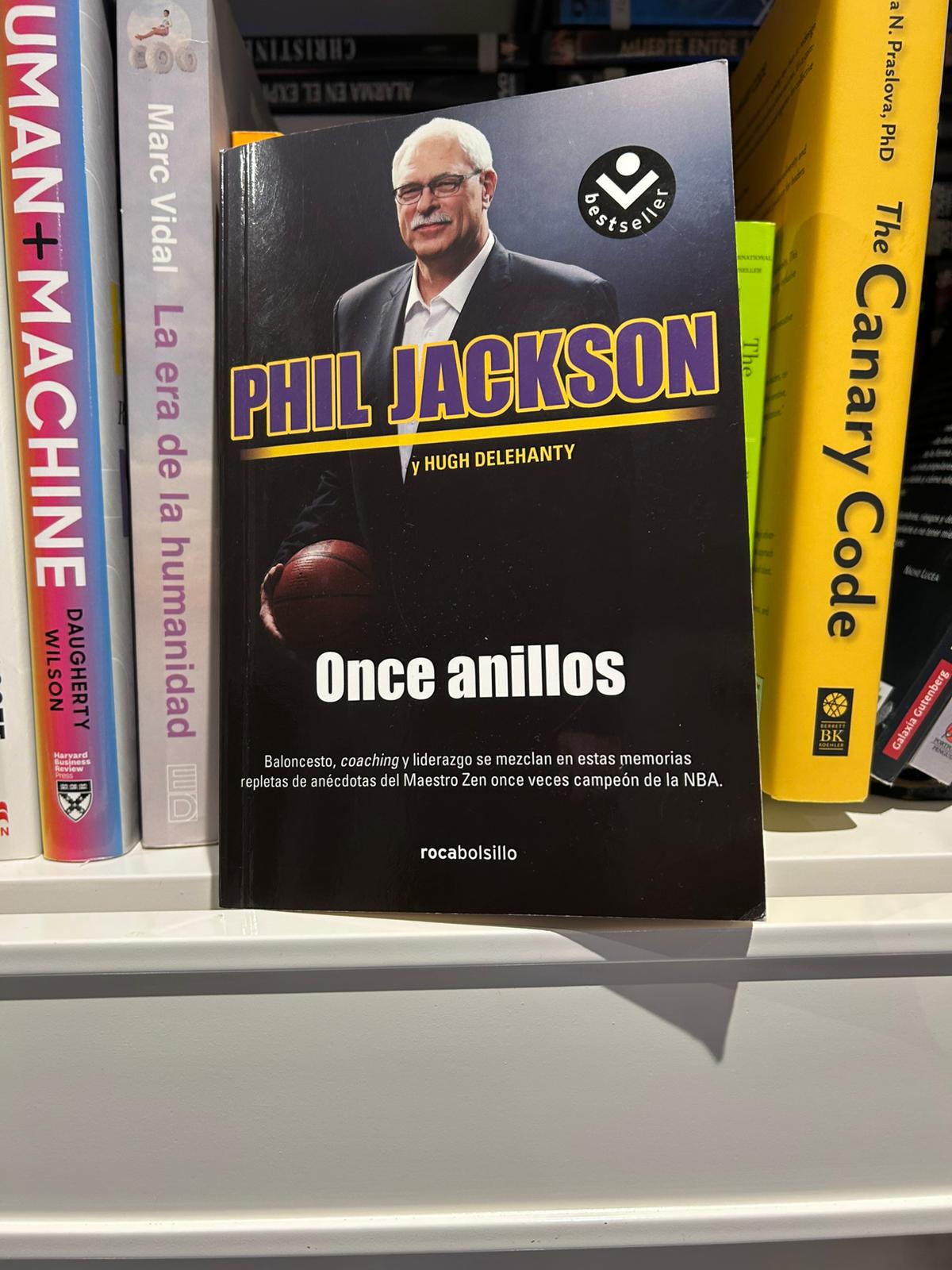 Libro Once anillos de Phil Jackson en una estantería junto a otros títulos de management