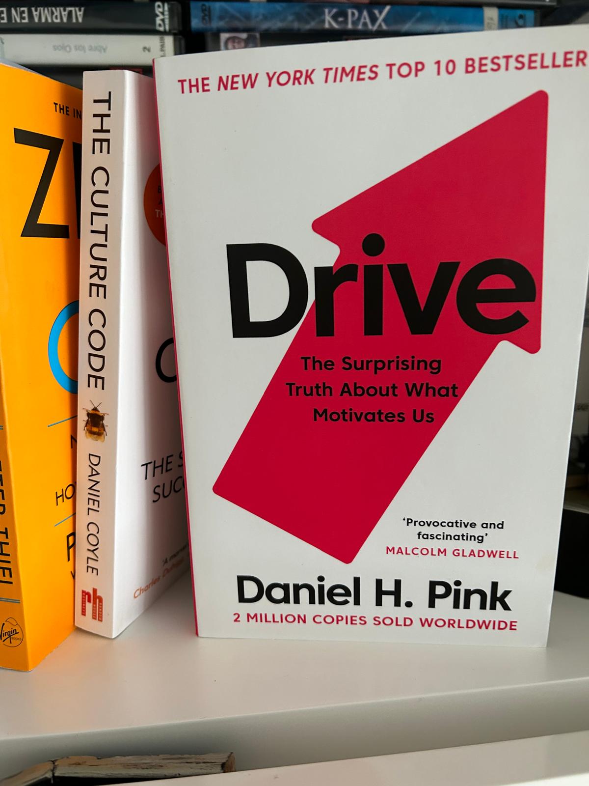 Libro Drive de Daniel H. Pink sobre la motivación junto a The Culture Code en una estantería