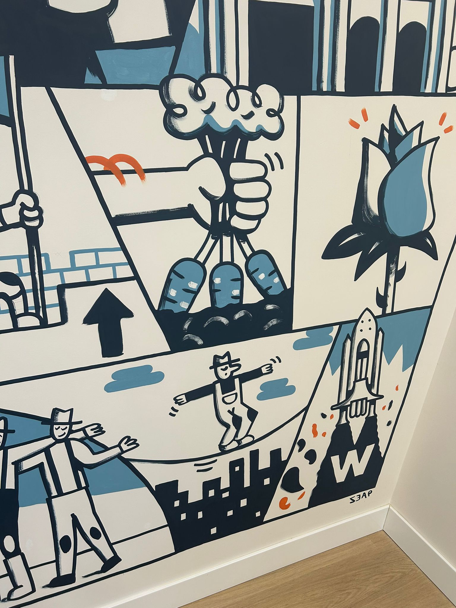 Detalle del mural con un equilibrista sobre la cuerda, simbolo de emprender desde cero, y una rosa